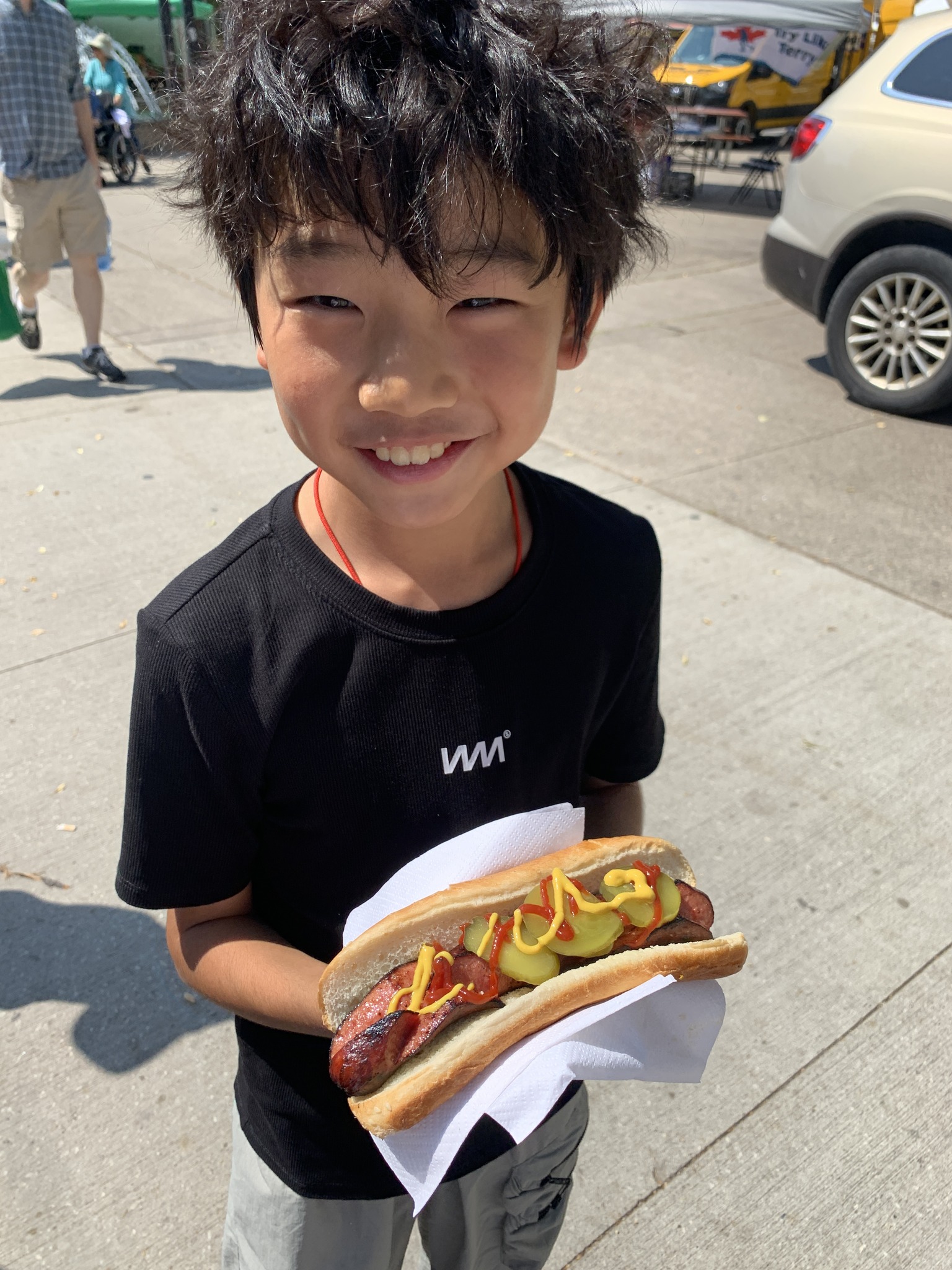 Student smiling holding hotdog in Toronto Open Gallery